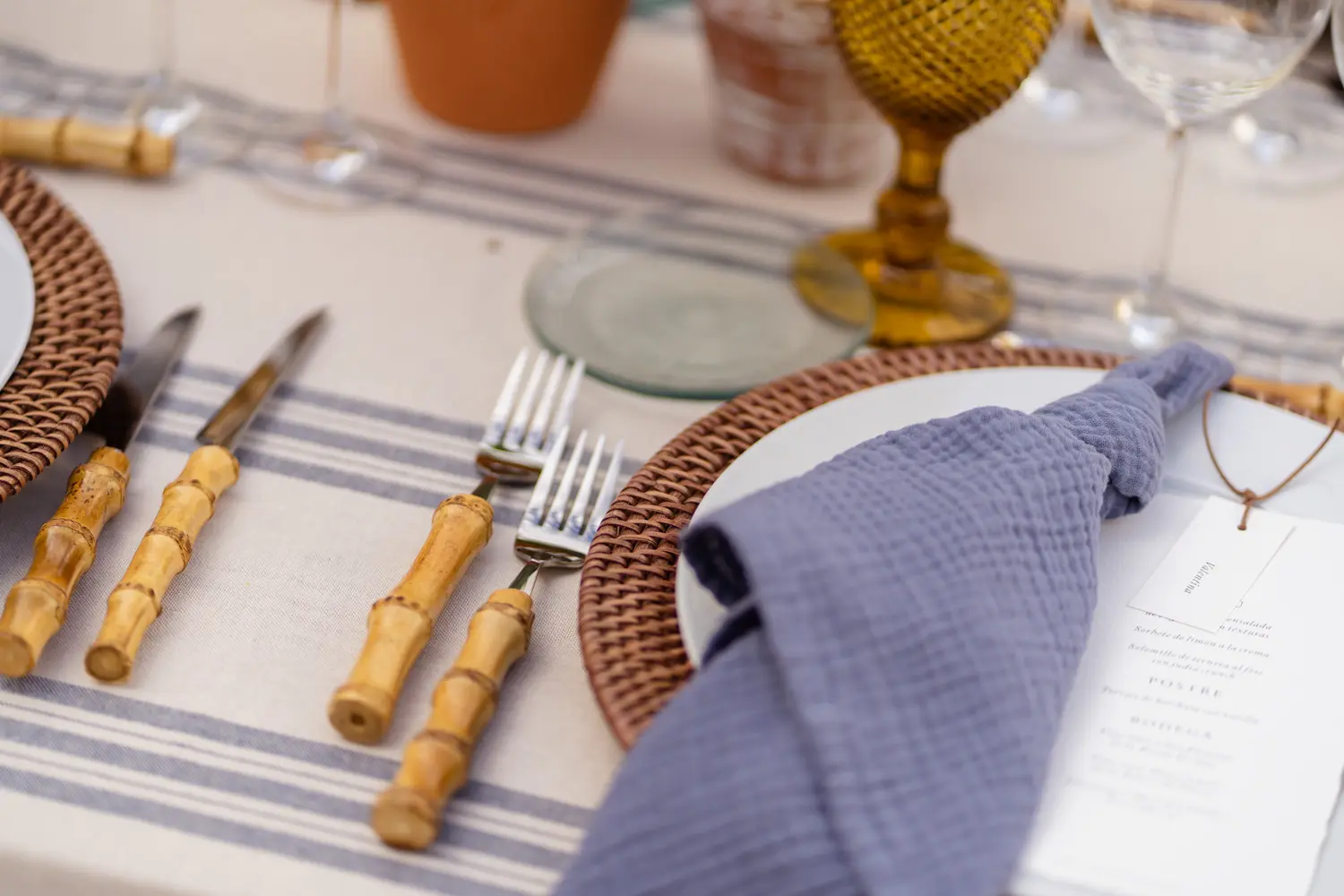 Mesa estilo Menorca con mantel de raya azul y servilleta de muselina