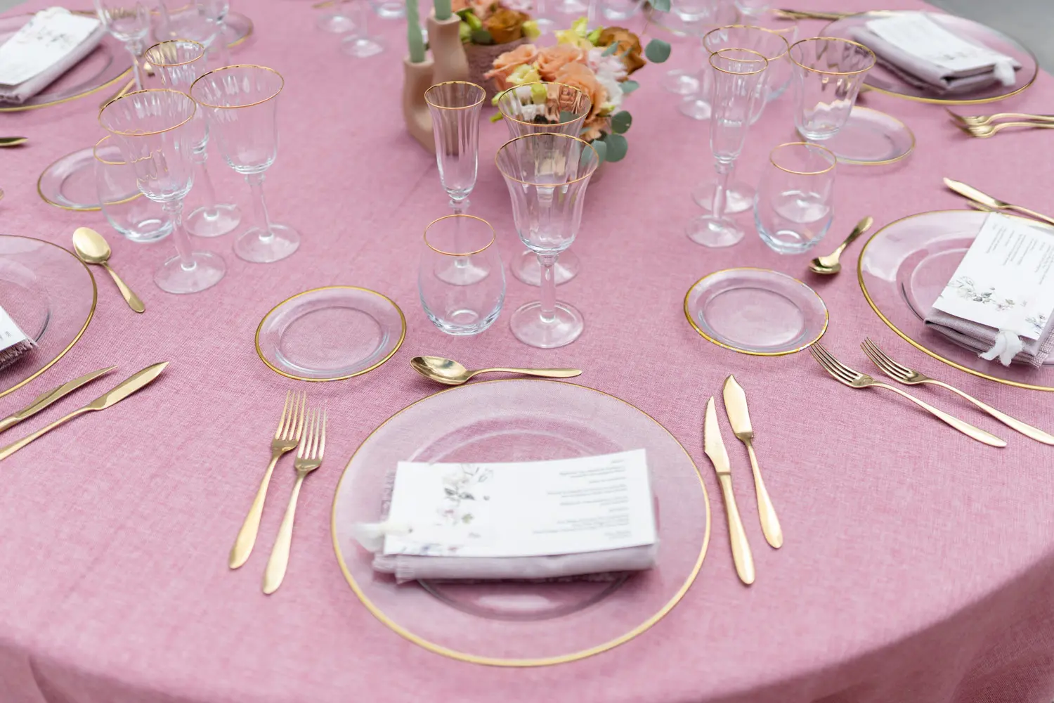 Plato de presentación de filo dorado sobre mantel rosa